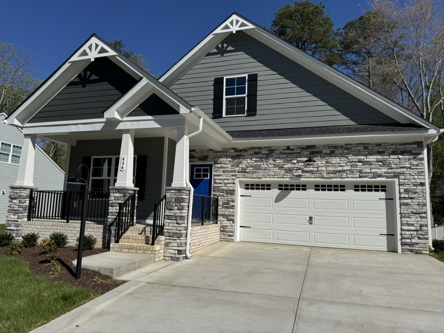 Modern suburban house with gray siding and stone facade—ideal for those seeking new homes in Richmond VA.