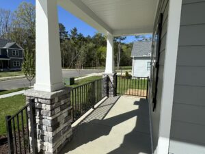 View of a house’s front porch in a sunny suburban neighborhood, showcasing new homes in Richmond VA.
