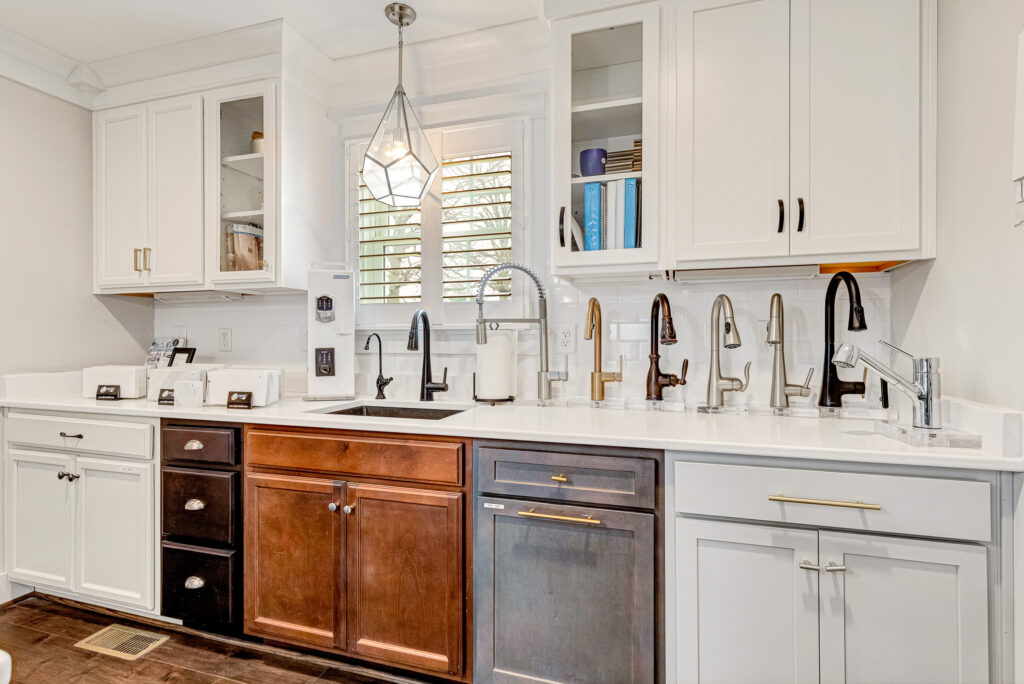 Design Center showcase: a kitchen display featuring various faucets and cabinetry in a showroom setting.