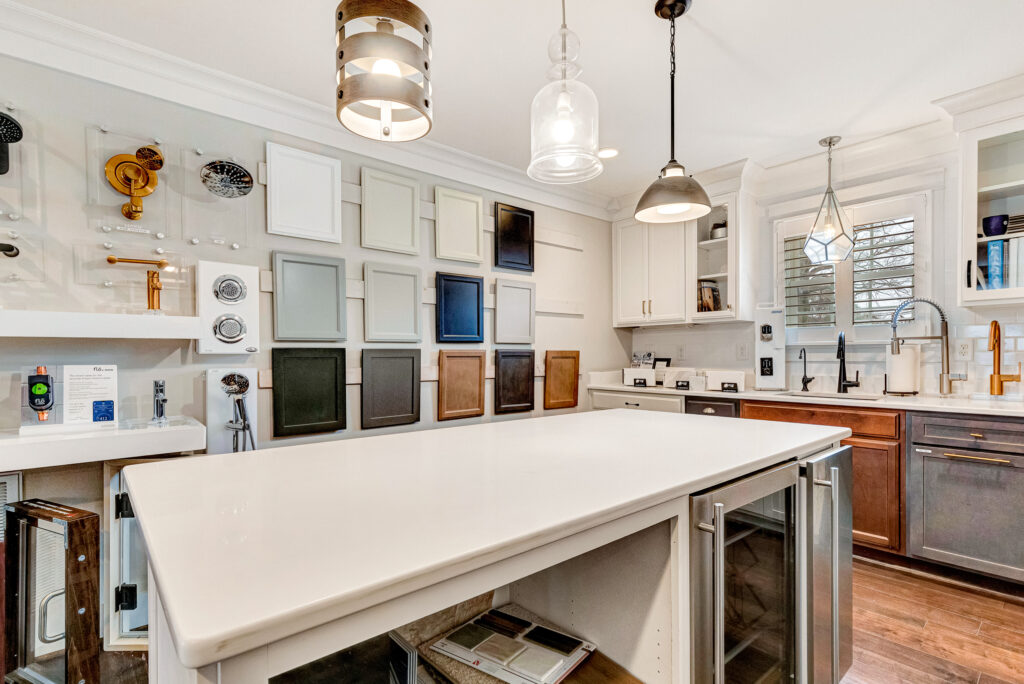 Design Center showcasing a modern kitchen with diverse cabinet and countertop samples under bright lighting and sleek decor.
