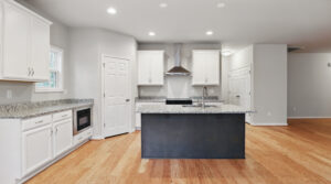 Modern Bethany kitchen with white cabinets, granite countertops, island, and stainless steel appliances.