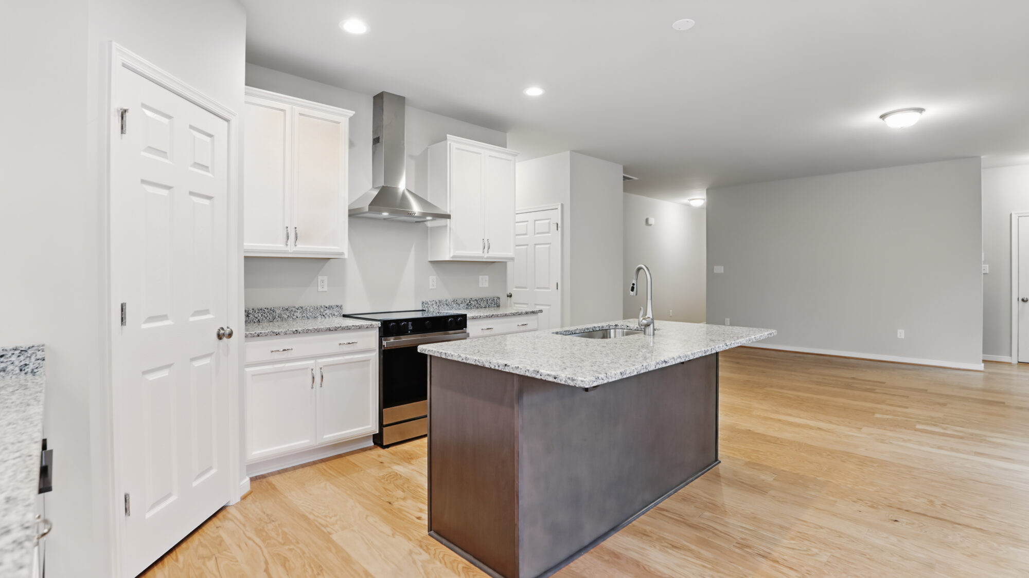 Modern Somerset Hill kitchen with white cabinets, granite countertops, island sink, and stainless steel appliances.