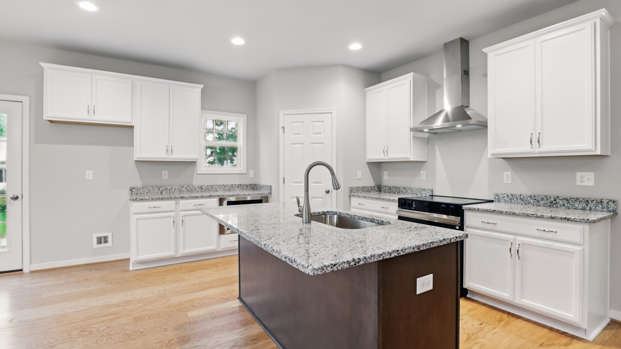 Modern Bethany kitchen with white cabinets, granite countertops, island sink, and stainless appliances.