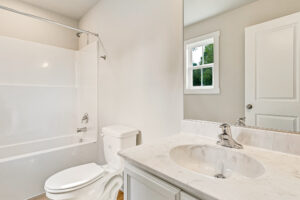 Bathroom at Somerset Hill with a white vanity, toilet, and a tub-shower combination.